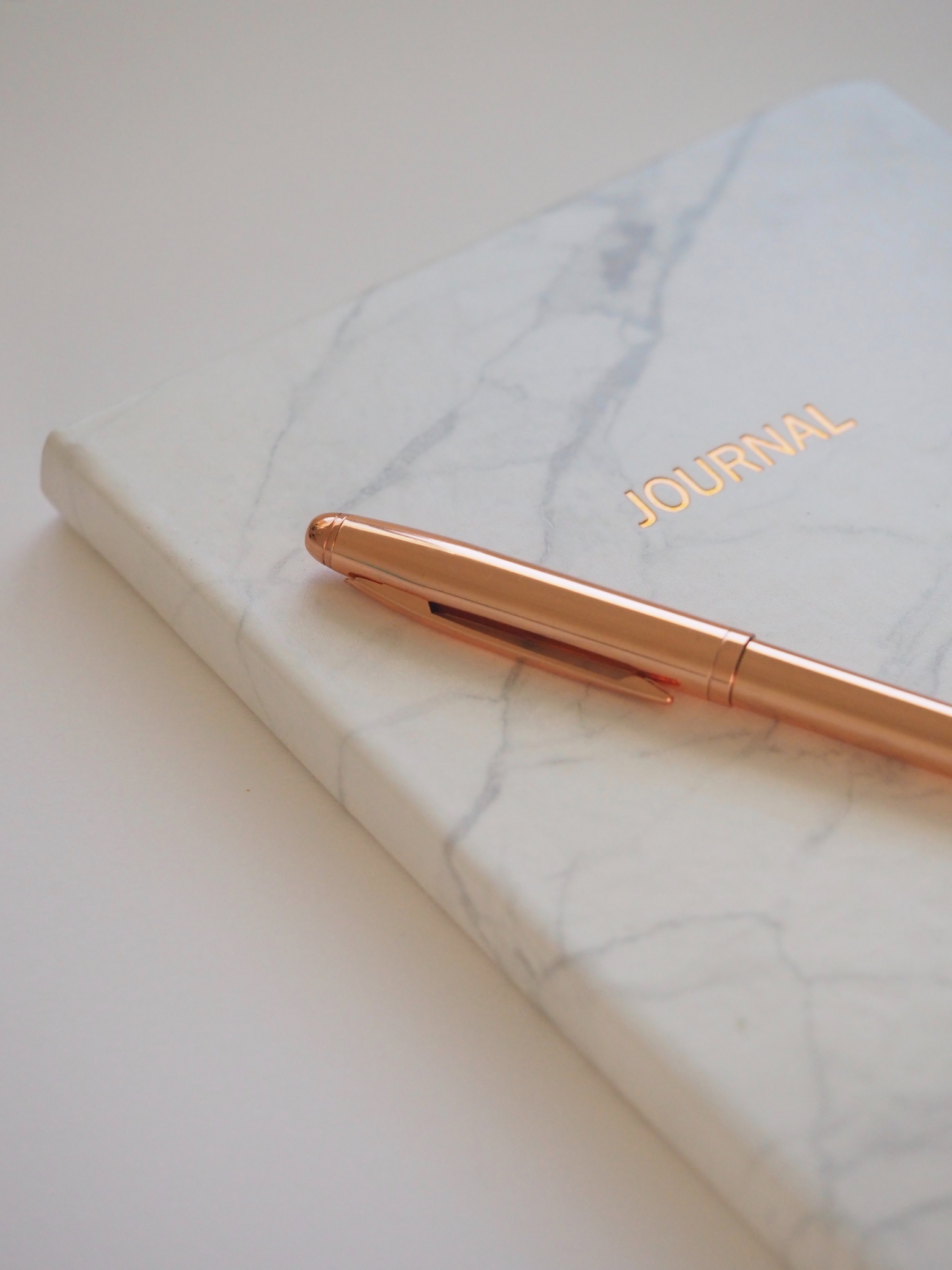 White journal and rose gold pen