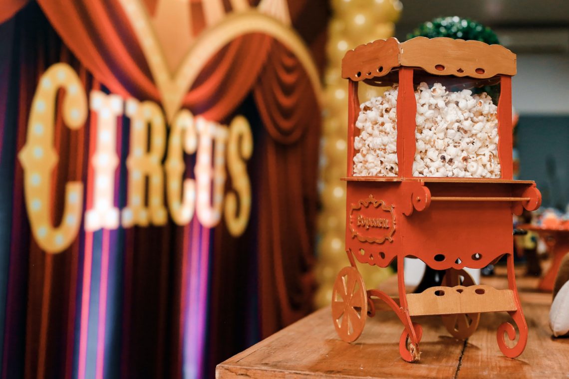 A popcorn trolley inside a theater with the sign "circus" in the background